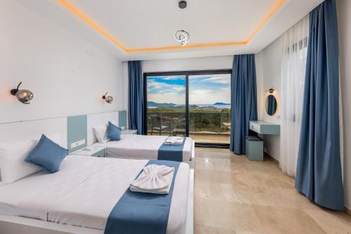 a hotel room with two beds and a large window at Villa Albedo Blue in Kaş