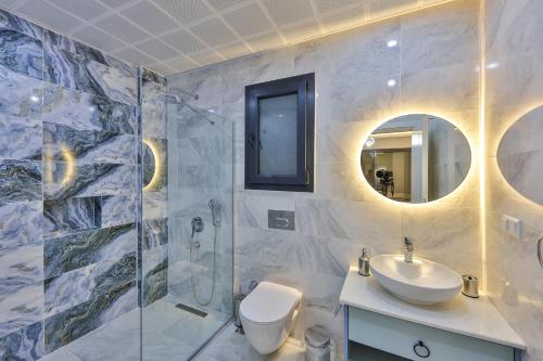 a bathroom with a sink toilet and a mirror at Villa Albedo Blue in Kaş
