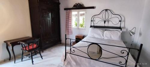 a bedroom with a bed and a chair and a window at Kıbrıs Evi (Cyprus House) in Mağusa