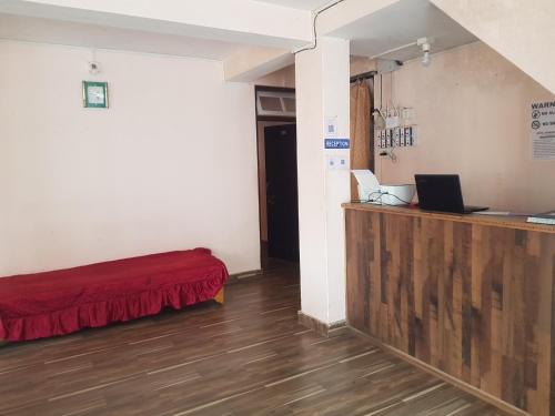 拉瓦格拉Hotel Rainbow Regency Ravangla South Sikkim的客房设有一张床、一张桌子和一台笔记本电脑