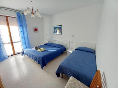 um quarto com 2 camas e uma janela em Alghero Tour em Alghero