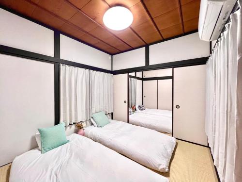 a room with two beds and two windows at AX-Ojima House in Tokyo