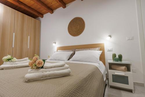 a bedroom with a large bed with towels on it at Al Cortiletto in Avola