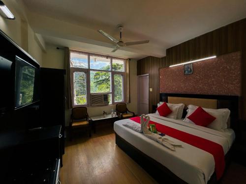 Hotel Eagle Nest Central Heated في دالهوزي: غرفه فندقيه سريرين وتلفزيون