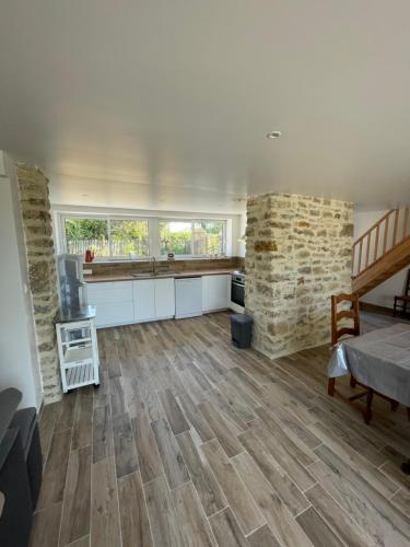 un grand salon avec parquet et murs en pierre dans l'établissement Le Ptit Normand, à Saint-Germain-de-Tournebut