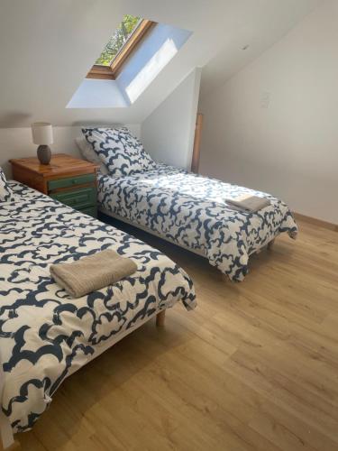 une chambre avec deux lits et une table et une fenêtre dans l'établissement Le Ptit Normand, à Saint-Germain-de-Tournebut