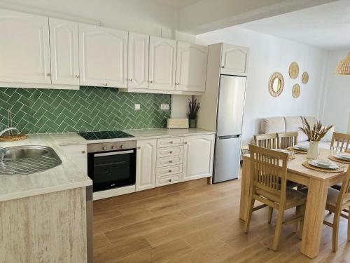 a kitchen with white cabinets and a table with a dining room at Precioso apartamento de 3 dormitorios con acceso directo a la playa in Altea
