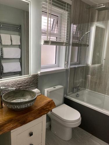 łazienka z umywalką, toaletą i wanną w obiekcie Clashmore Wood w mieście Dornoch
