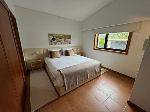 um quarto com uma cama e uma janela em Panoramic Beachfront Villa - Direct Beach Access em Esposende