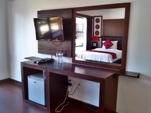 a bedroom with a desk with a mirror and a bed at D'Mell Bali in Nusa Dua