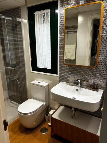 ein Badezimmer mit einem WC, einem Waschbecken und einem Spiegel in der Unterkunft Apartamento Bajondillo Playa y piscina in Torremolinos