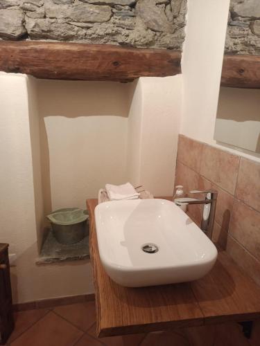 a white sink in a bathroom with a stone wall at Rota d'Amont in Stroppo