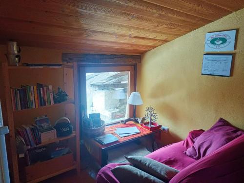 a room with a bed and a table with a window at Rota d'Amont in Stroppo