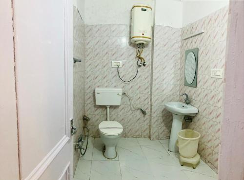 a bathroom with a toilet and a sink at Hotel Eagle Nest Central Heated in Dalhousie