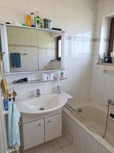 a bathroom with a sink and a bath tub at Zimmer mit Sonnenaufgang und ruhiger Innenhof Obergeschoss bei Koberstein in Tutzing