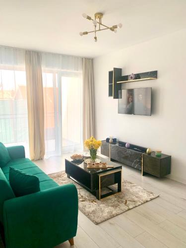un soggiorno con divano verde e tavolino da caffè di Apartament 1 camera a Sancraiu de Mures