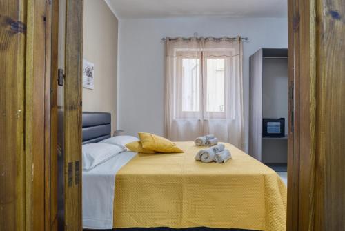 サン・ヴィート・ロ・カーポにあるDaphne B&Bのベッドルーム1室(黄色い毛布付きのベッド1台付)