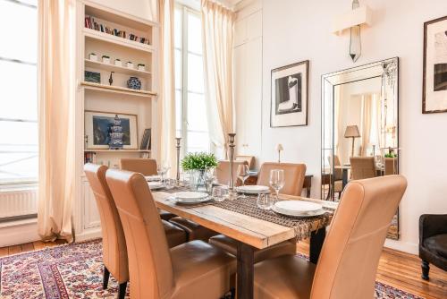 une salle à manger avec une table et des chaises dans l'établissement Luxury typical Parisian flat - 5 min from Louvre, à Paris