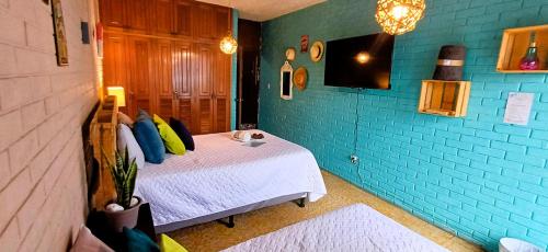a bedroom with a bed and a blue wall at Hostal de Lucca in Guatemala