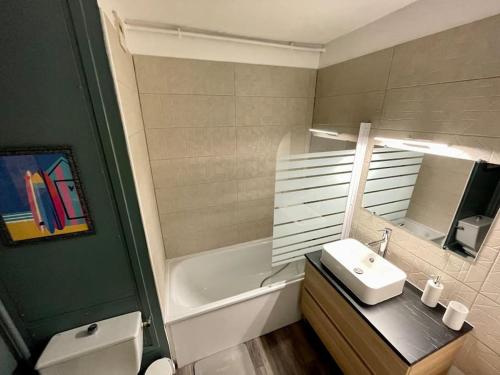 une salle de bain avec un lavabo et une baignoire dans l'établissement Appartement Le petit Génois à port Olona, à Les Sables-dʼOlonne