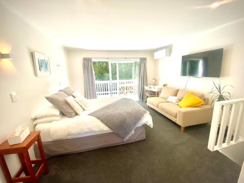 a bedroom with a bed and a couch at 2 Mile Bay Guesthouse in Taupo