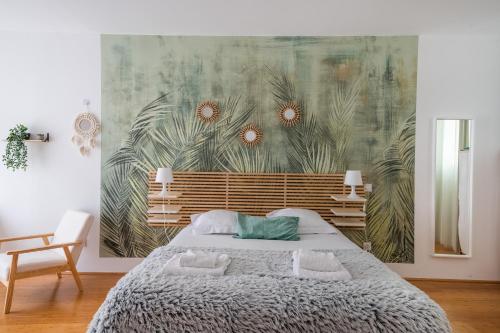 - une chambre avec un lit orné d'une fresque murale dans l'établissement Le Bambou: Grand studio au calme, Climatisé, 5 min de la Gare, à Bordeaux