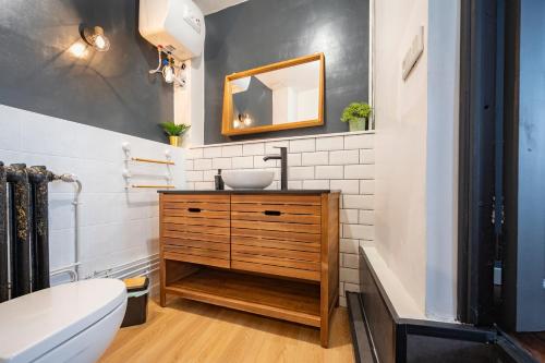 uma casa de banho com um lavatório e um espelho em Appartement spacieux et élégant avec jardin em Montivilliers