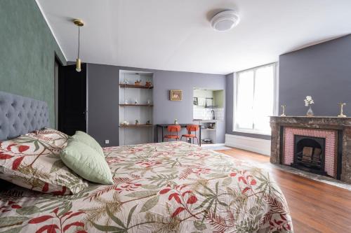 um quarto com uma cama e uma lareira em Appartement spacieux et élégant avec jardin em Montivilliers