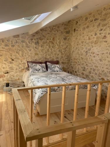 un lit dans une chambre avec des murs en pierre dans l'établissement Le cabanon d’Endoume, à Marseille