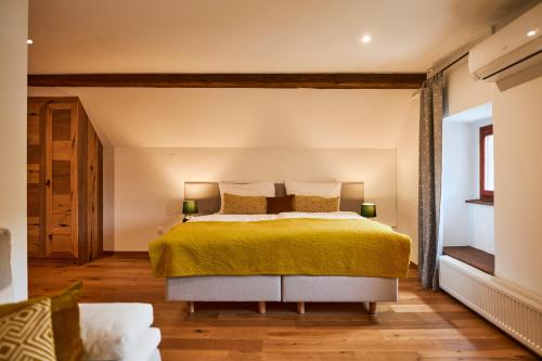 a bedroom with a large bed with a yellow bedspread at Hotel Pok Garni in Brezovica