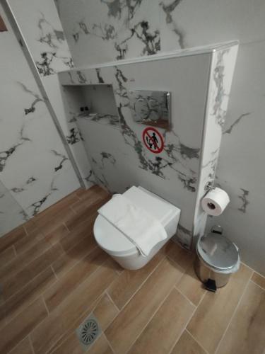 a bathroom with a toilet and a sign on the wall at OLYMPUS HILL in Litochoro