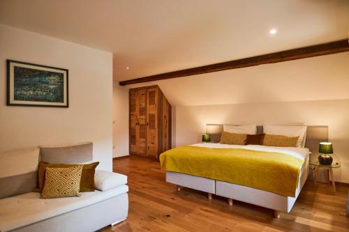 a bedroom with a yellow bed and a couch at Hotel Pok Garni in Brezovica