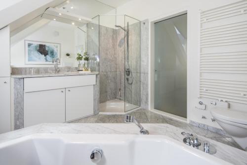 a bathroom with a tub and a sink and a toilet at Hallstatt Hideaway - Adults only in Hallstatt