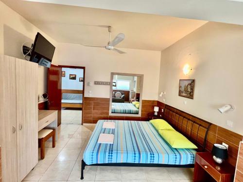 a bedroom with a bed and a sink and a mirror at SCALA APARTS & STUDIOS - Rhodes in Afantou