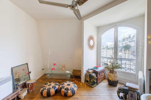 un salon avec une grande fenêtre et une table dans l'établissement Paris 5ème - Grand Appartement, à Paris