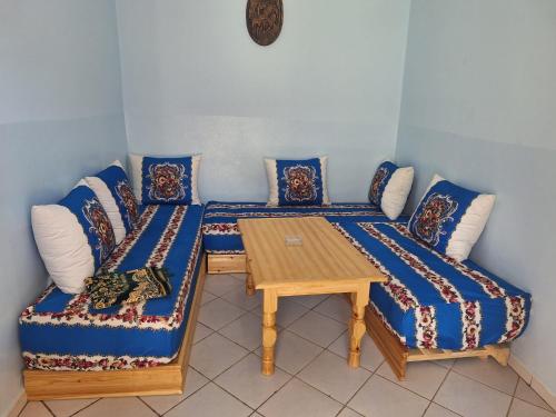 ein Zimmer mit einem Sofa und einem Tisch mit Kissen in der Unterkunft Maison Touria in Ouzoud
