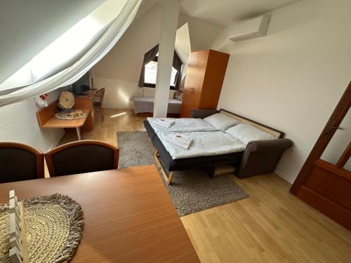 a living room with a bed and a table at Diamant Apartmanház in Eger