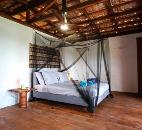 a bed with a mosquito net in a room at Sonho Non in Santana