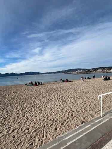 a group of people sitting on a beach at Cannes, la Croisette, Palais Miramar in Cannes