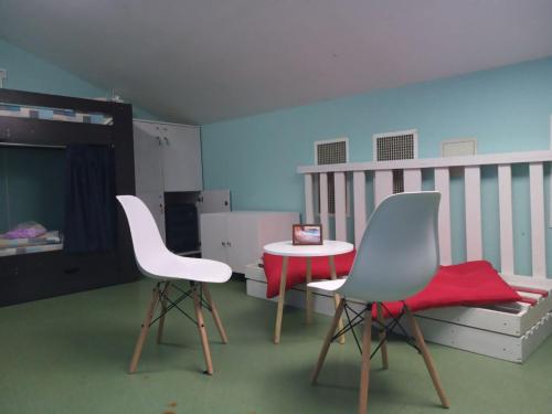 a room with two chairs and a table and a crib at Bulgakoff in Kyiv