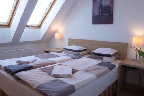 2 Betten in einem Zimmer mit Oberlichtern in der Unterkunft Gárdonyi Apartman in Eger