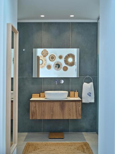 a bathroom with a sink and a picture of donuts at Villa Le22, 180 panoramic sea views, Paros in Kampos Paros