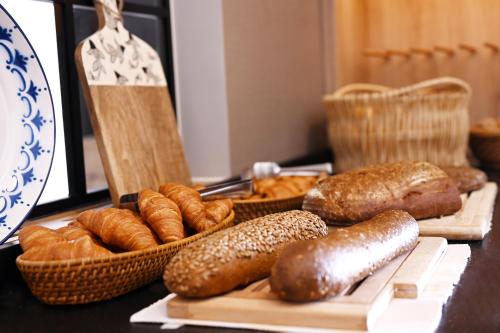 a table with different types of bread and pastries at Altes Kurhaus Landhotel in Trabelsdorf