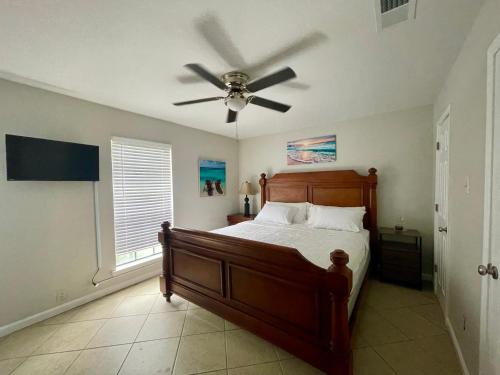 a bedroom with a bed with a ceiling fan at Cottage Hill Comfort in Mobile