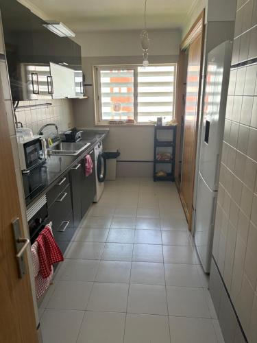 uma pequena cozinha com um lavatório e um fogão em Ranjeet felizarda em Lisboa