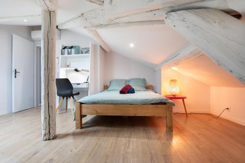 une chambre avec un lit, un bureau et une chaise dans l'établissement La Chic Comédie - 2 chambres - hypercentre - Wifi, à Montpellier