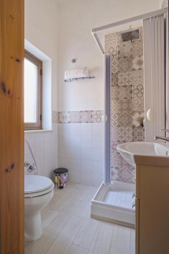 a bathroom with a shower and a toilet and a sink at Daphne B&B in San Vito lo Capo