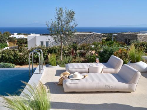 a white couch sitting on a patio next to a pool at Villa Le22, 180 panoramic sea views, Paros in Kampos Paros