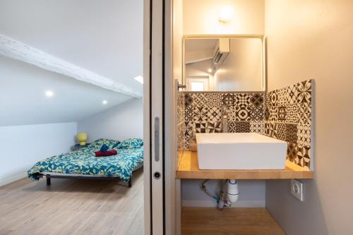 une salle de bain avec un lavabo et un miroir dans l'établissement La Chic Comédie - 2 chambres - hypercentre - Wifi, à Montpellier