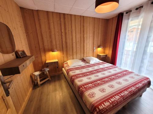 ein Schlafzimmer mit einem Bett in einem Zimmer mit Holzwänden in der Unterkunft Appartement Les Gets, 3 pièces, 6 personnes - FR-1-598-76 in Les Gets